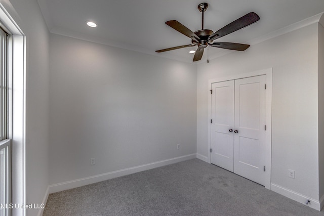 unfurnished bedroom with ceiling fan, crown molding, a closet, and light carpet