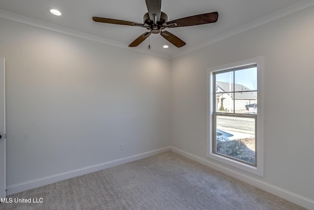 carpeted spare room featuring ceiling fan and crown molding