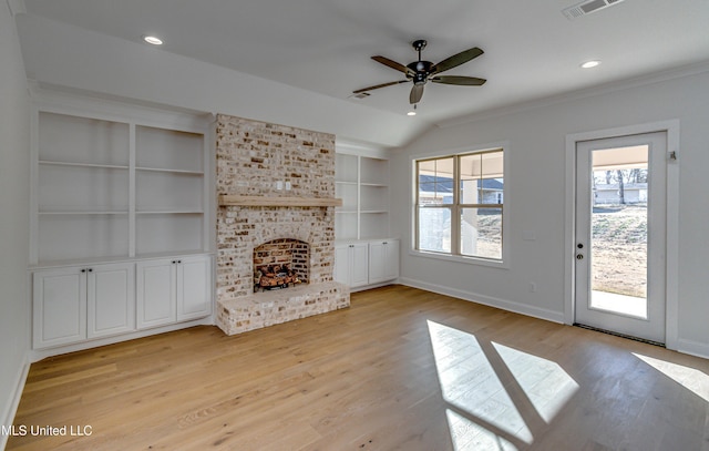 unfurnished living room featuring lofted ceiling, built in shelves, a fireplace, light wood-type flooring, and ceiling fan