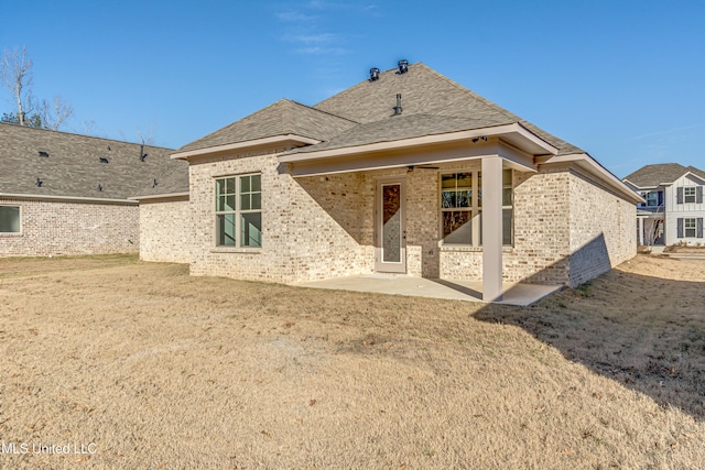 back of house featuring a patio area and a lawn