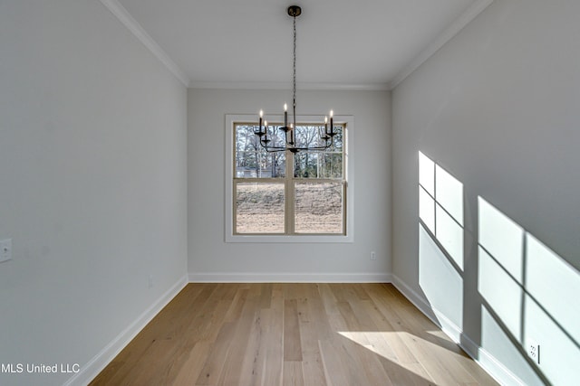 unfurnished dining area with crown molding, light wood-type flooring, and a notable chandelier