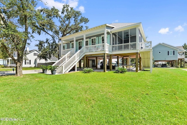 back of house featuring a sunroom, ceiling fan, and a yard