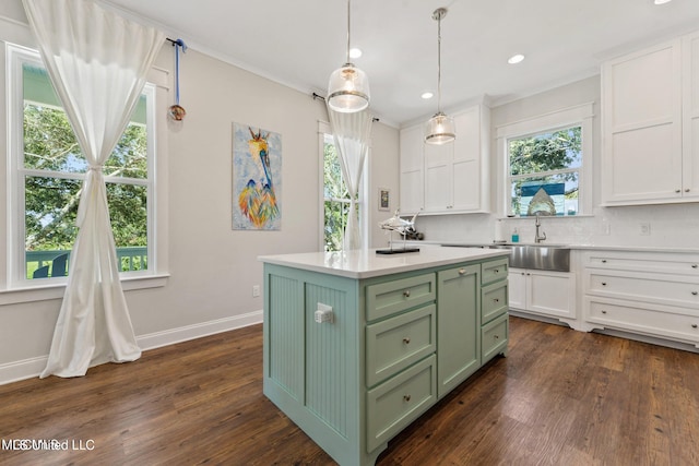 kitchen with dark hardwood / wood-style floors, tasteful backsplash, green cabinetry, and a center island