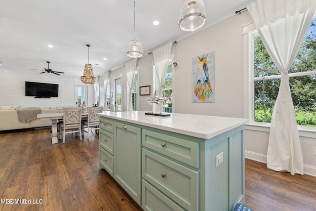 kitchen with dark hardwood / wood-style floors, plenty of natural light, and a kitchen island