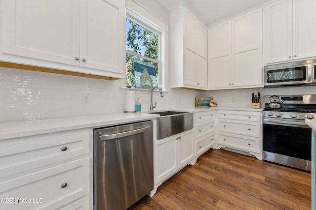 kitchen featuring white cabinetry, sink, appliances with stainless steel finishes, backsplash, and dark wood-type flooring