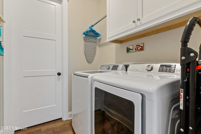 clothes washing area featuring dark hardwood / wood-style flooring, cabinets, and washer and clothes dryer