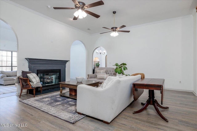 living room featuring hardwood / wood-style flooring, ceiling fan, and ornamental molding