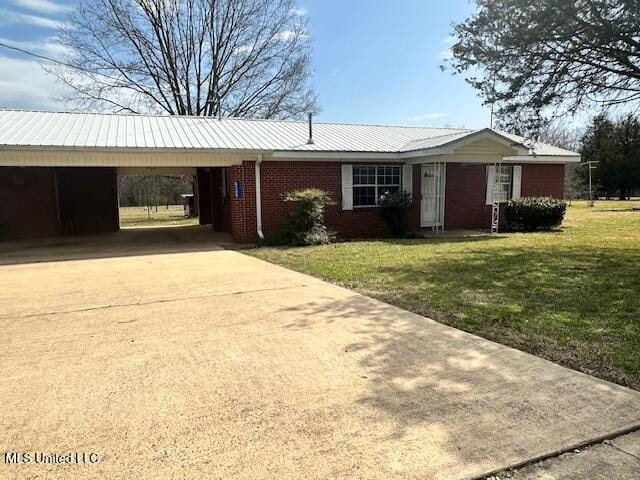 single story home with brick siding, driveway, metal roof, and a front yard