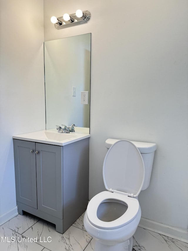 100 Warren St, Como, MS 38619 - half bath with marble look tiles, vanity, toilet, and baseboards