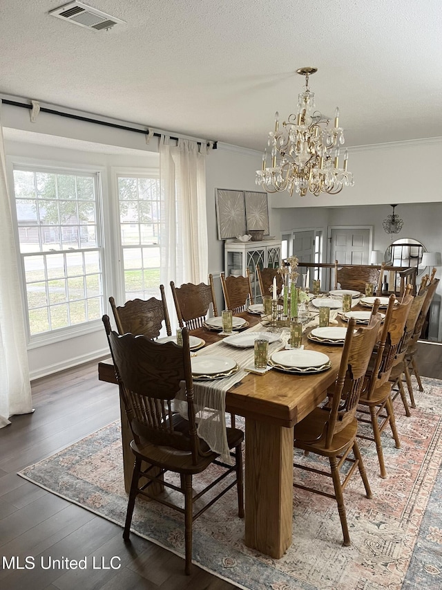 1202 Hemingway St, Greenwood, MS 38930 - dining space featuring crown molding, a notable chandelier, wood finished floors, and visible vents