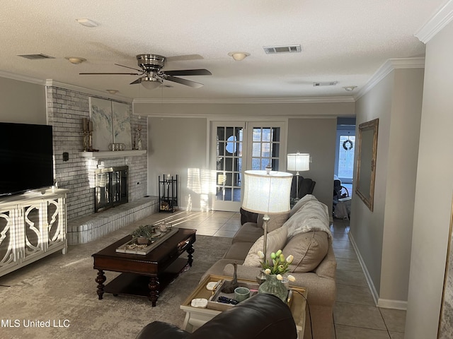 1202 Hemingway St, Greenwood, MS 38930 - tiled living room with a brick fireplace, visible vents, a textured ceiling, and ceiling fan