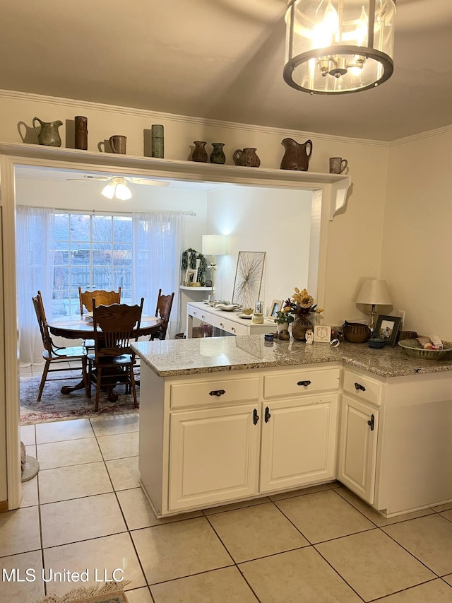 1202 Hemingway St, Greenwood, MS 38930 - kitchen with white cabinets, a peninsula, light tile patterned flooring, and light stone countertops