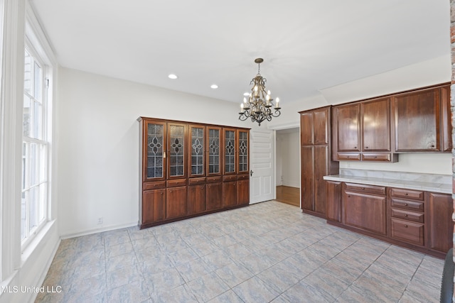 kitchen featuring baseboards, light countertops, a wealth of natural light, and pendant lighting