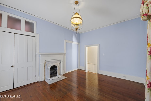 unfurnished living room with ornamental molding, a fireplace with flush hearth, wood-type flooring, and baseboards