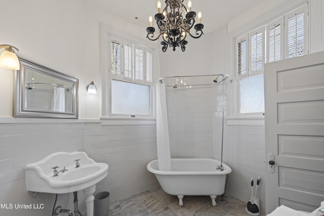 bathroom featuring a shower with curtain, a healthy amount of sunlight, a freestanding bath, and tile walls