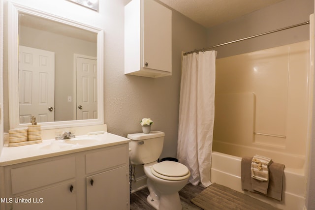 full bathroom with hardwood / wood-style floors, vanity, shower / bath combination with curtain, toilet, and a textured ceiling