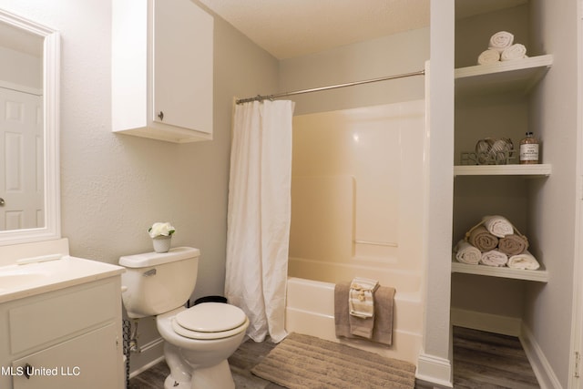 full bathroom with vanity, shower / bath combination with curtain, hardwood / wood-style flooring, toilet, and a textured ceiling