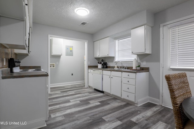 kitchen with sink, white dishwasher, a textured ceiling, white cabinets, and range