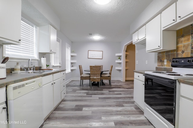 kitchen featuring white appliances, backsplash, white cabinets, sink, and a textured ceiling