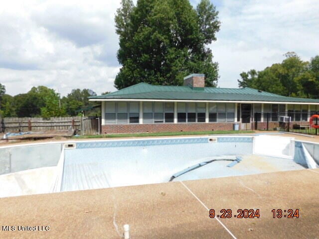 view of swimming pool featuring a sunroom