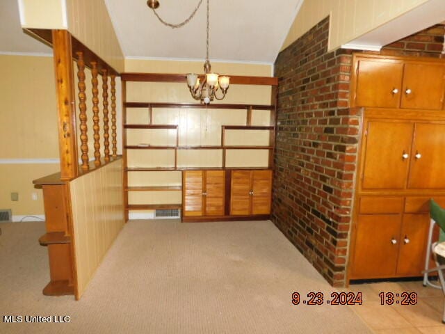 dining space with light carpet, an inviting chandelier, ornamental molding, and vaulted ceiling