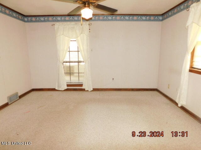 empty room with ceiling fan and carpet floors