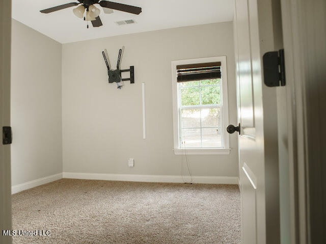 carpeted spare room with ceiling fan