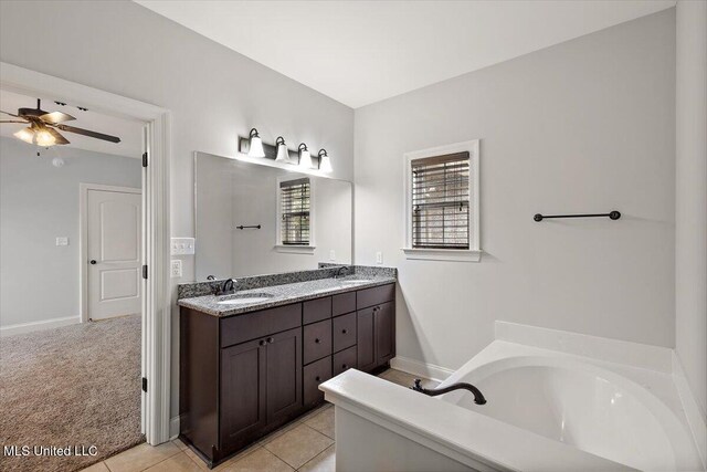 bathroom featuring tile patterned flooring, vanity, ceiling fan, and a tub to relax in