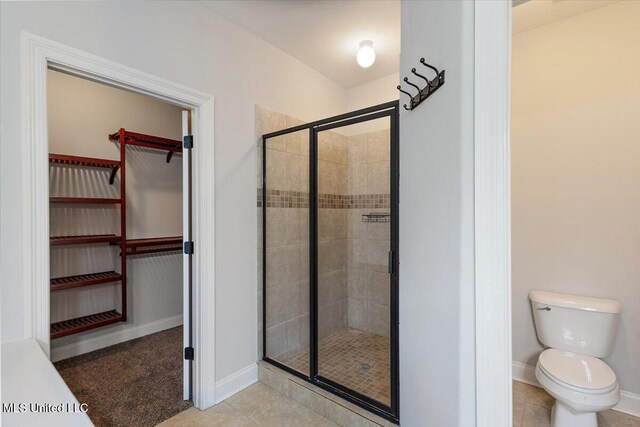 bathroom featuring toilet, tile patterned floors, and walk in shower