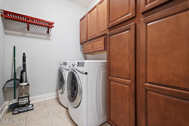 laundry room with cabinets, light tile patterned floors, and independent washer and dryer