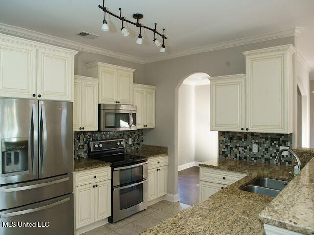 kitchen featuring dark stone counters, sink, and stainless steel appliances