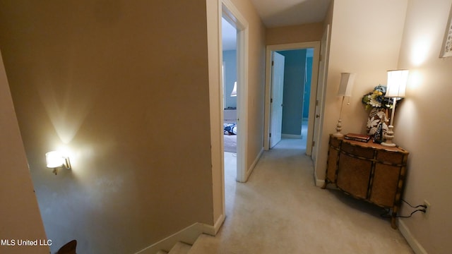 hallway featuring light colored carpet