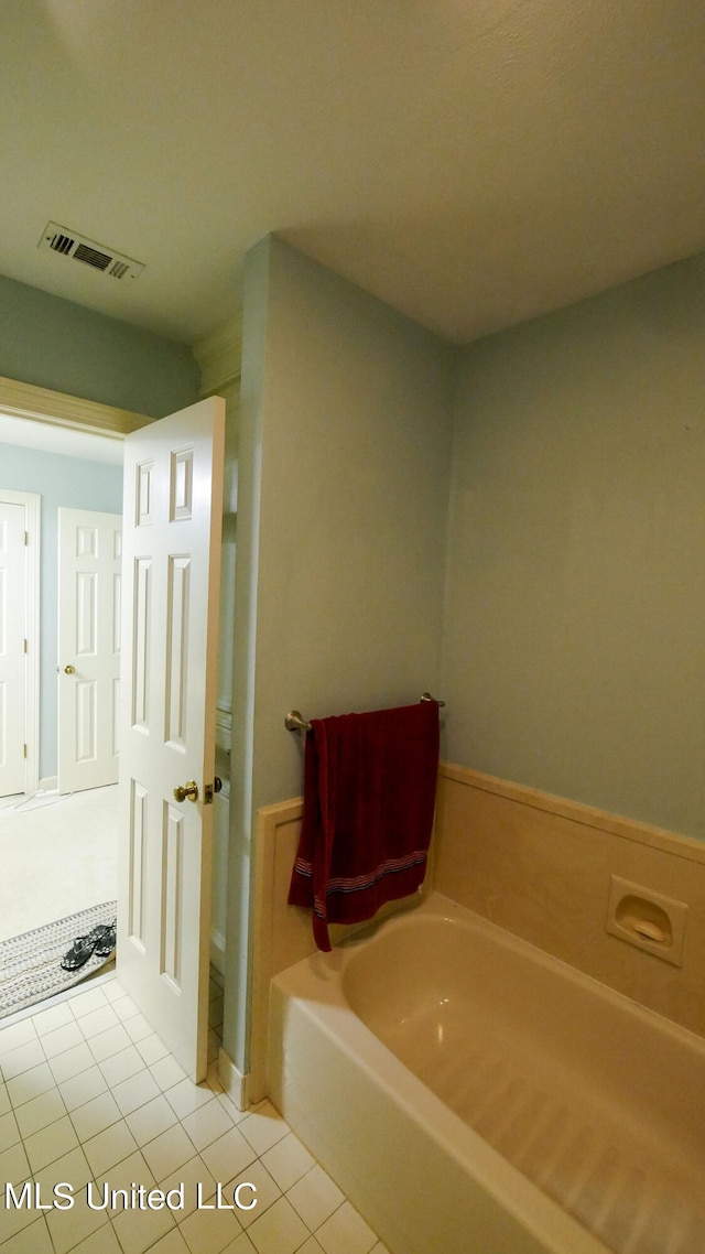 bathroom with tile patterned floors and a tub