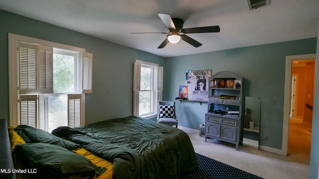 carpeted bedroom with multiple windows and ceiling fan