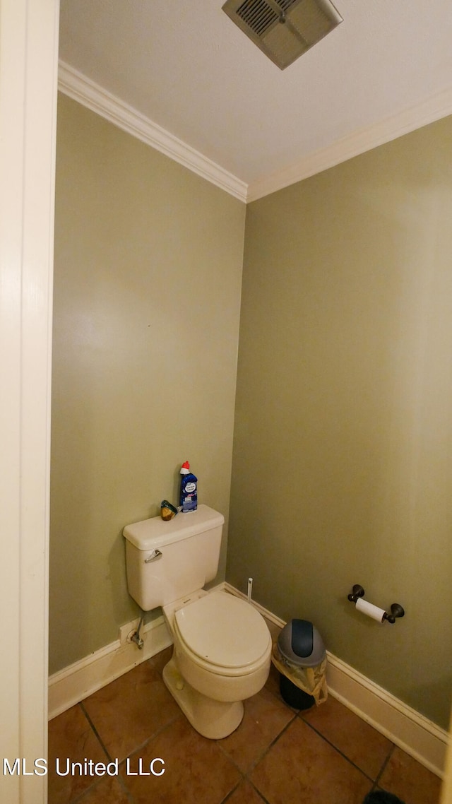 bathroom with toilet, ornamental molding, and tile patterned flooring