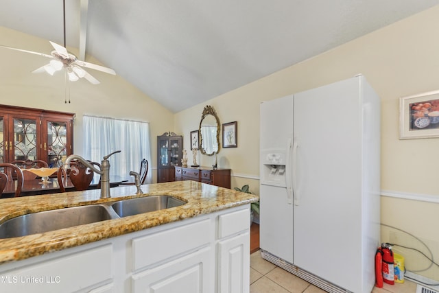 6658 Ahekolo Cir, Diamondhead, MS 39525 - kitchen featuring white refrigerator with ice dispenser, a ceiling fan, light tile patterned flooring, white cabinetry, and light stone countertops