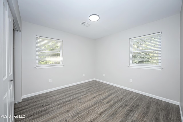 unfurnished bedroom with a closet and dark hardwood / wood-style flooring