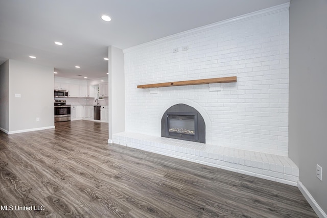 unfurnished living room featuring a fireplace and dark hardwood / wood-style flooring