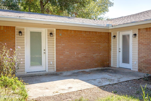 view of exterior entry with a patio