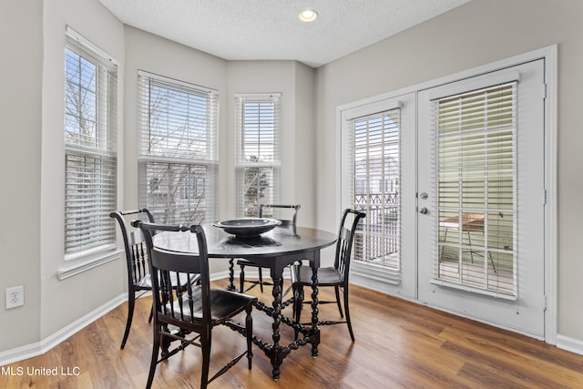 dining space featuring a textured ceiling, hardwood / wood-style flooring, and a wealth of natural light