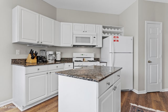 kitchen with white appliances, a center island, white cabinetry, and dark hardwood / wood-style flooring