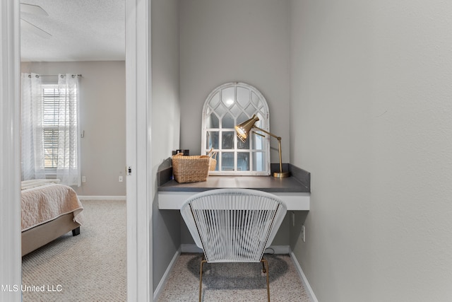 home office with built in desk and a textured ceiling