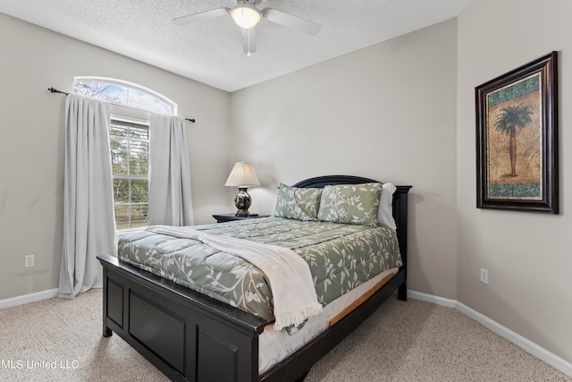 bedroom featuring light carpet, a textured ceiling, and ceiling fan