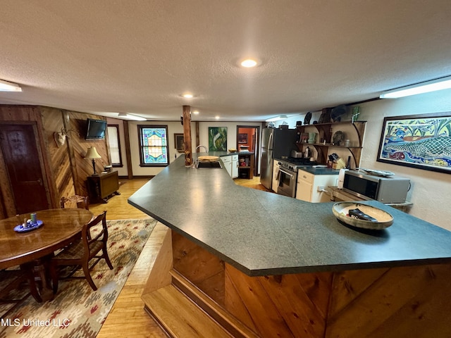 14 Fava St, Alligator, MS 38720 - kitchen featuring stainless steel appliances, dark countertops, a textured ceiling, light wood-style flooring, and open shelves