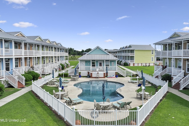 view of pool featuring a patio area and a yard