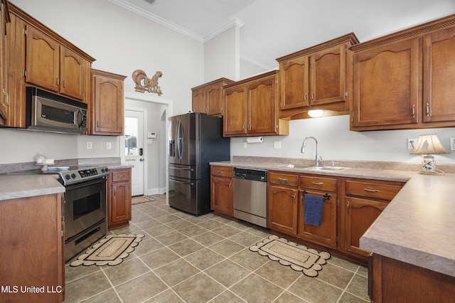 kitchen featuring crown molding, stainless steel appliances, dark tile patterned flooring, and sink