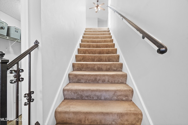 staircase with a textured ceiling