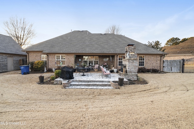 rear view of house featuring a fireplace and a patio