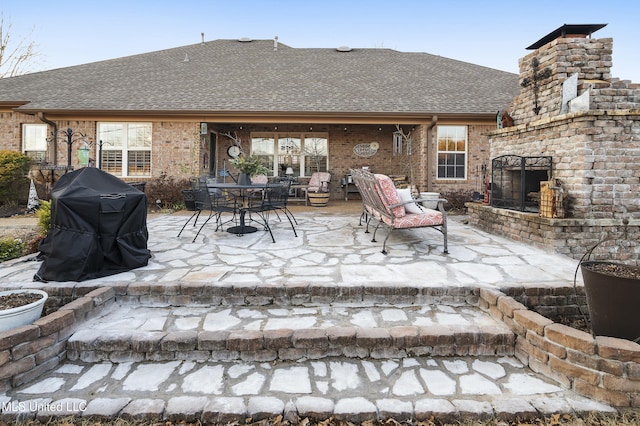 view of patio / terrace with an outdoor brick fireplace and grilling area