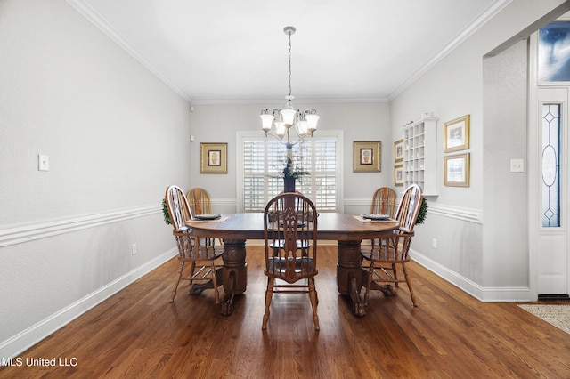 dining area featuring dark wood-type flooring, ornamental molding, and a chandelier